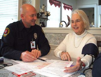 Firefighter Visiting With Older Woman