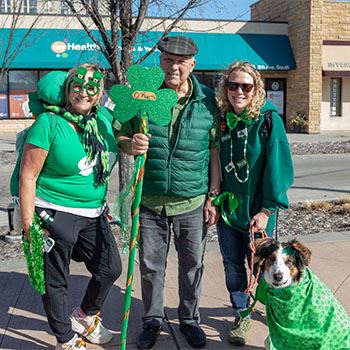 A group of adults with their dog dressed in green for the World's Shortest St. Patrick's Day P